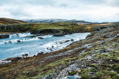 Scenic view of waterfall against sky
