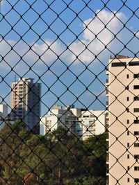 Buildings seen through chainlink fence