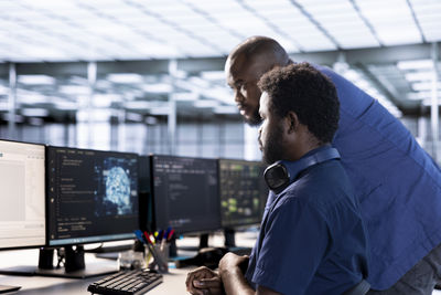 Side view of man using laptop at airport