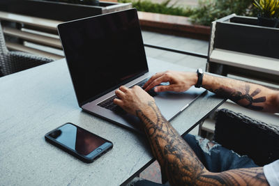 Cropped hands using laptop on table