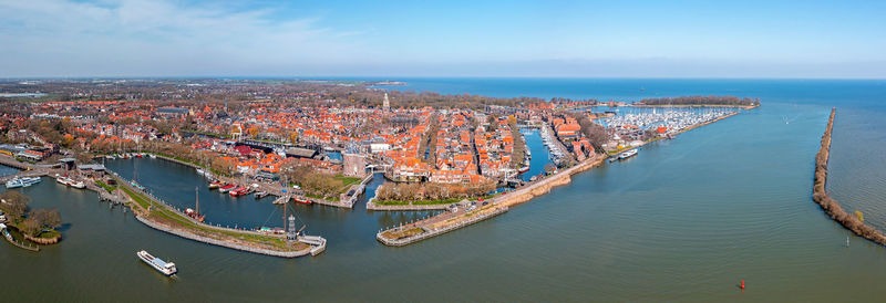 High angle view of city by sea against sky