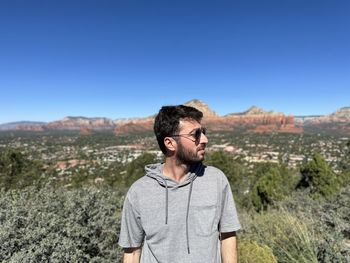 Side view of young man standing against mountain