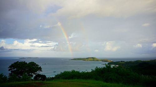 Scenic view of rainbow over land against sky