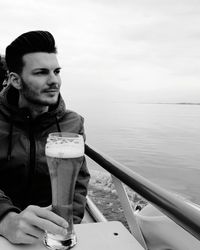 Thoughtful man having beer while traveling on boat at sea