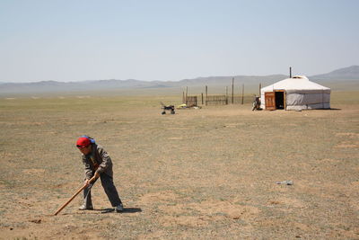 A boy finds a mouse hole in the solitary meadow, tuv province, mongolia.