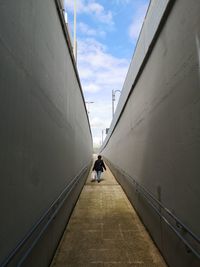 Low angle view of people walking in tunnel
