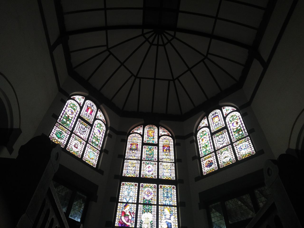 LOW ANGLE VIEW OF STAINED GLASS WINDOW IN CHURCH