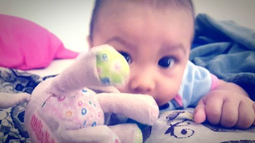 Close-up portrait of cute baby playing with toy at home