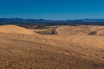 Scenic view of desert against blue sky