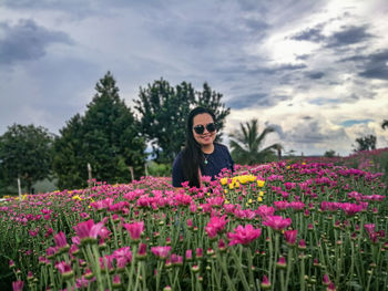 Portrait of woman with pink flowers in garden