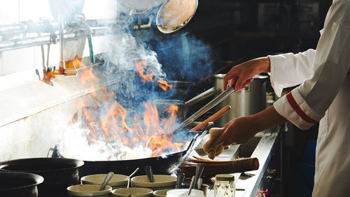 Chef stir fry busy cooking in kitchen. chef stir fry the food in a frying pan