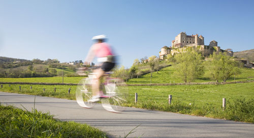 Blurred motion of man riding motorcycle on road against sky