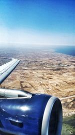 Close-up of airplane wing against clear blue sky