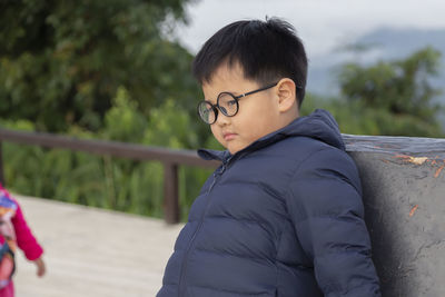 Portrait of boy standing by railing