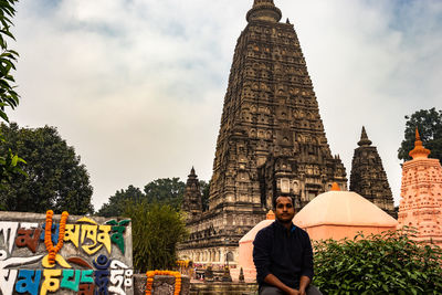 Portrait of man sitting against temple