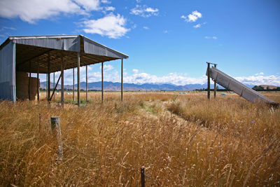 Lifeguard hut on field against sky