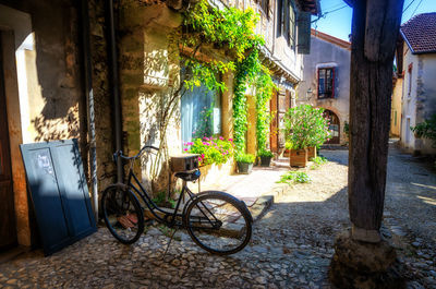 Bicycle on alley amidst buildings in city