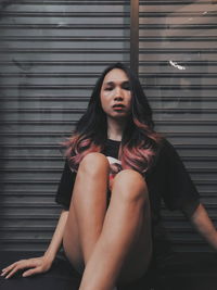 Portrait of young woman sitting outdoors