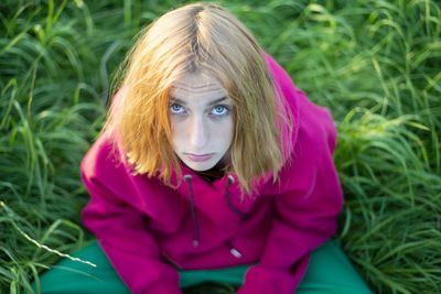 Portrait of young woman sitting on field