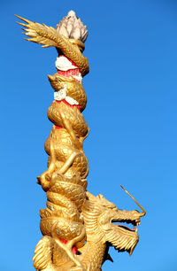 Low angle view of statue against blue sky