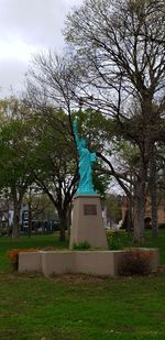 Statue in park against sky