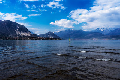 Scenic view of sea by mountains against sky