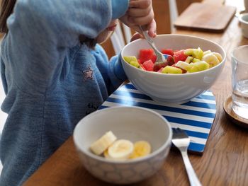 Midsection of man preparing food in bowl on table