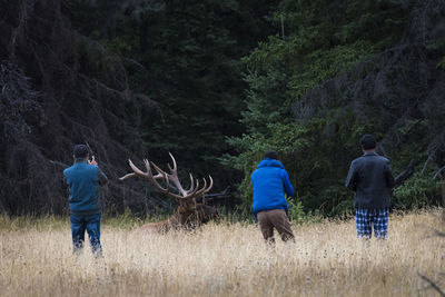 Rear view of men standing on field