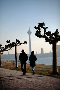 People walking in park against clear sky