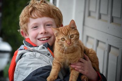 Portrait of smiling boy holding a cat