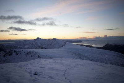 Scenic view of snow covered mountains against sky during sunset