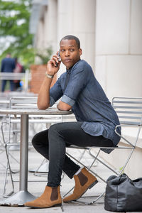 Full length of young man sitting on seat