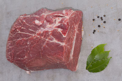 Directly above shot of red meat by spices on cutting board