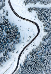 Aerial view of road passing through snow covered land