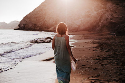 Rear view of woman standing on beach