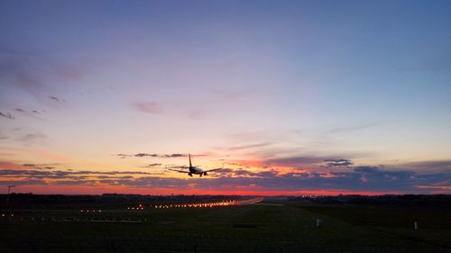 Scenic view of silhouette field against sky during sunset