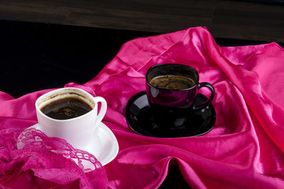 High angle view of coffee cups with fabric on table