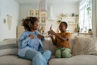 Side view of woman using digital tablet at home