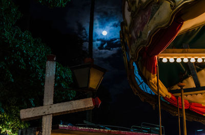 Low angle view of illuminated merry-go-round against sky