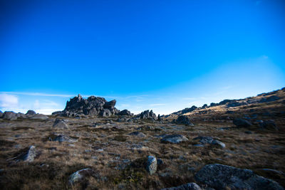 Rocks on landscape against blue sky