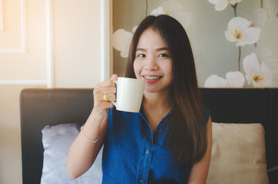 Portrait of smiling woman holding coffee cup