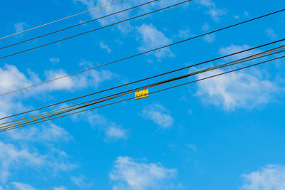 Low angle view of cables against blue sky