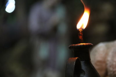 Close-up of lit candles on wood