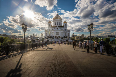 Group of people in temple against cloudy sky