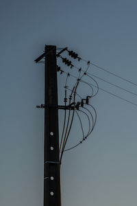 Low angle view of silhouette pole against sky