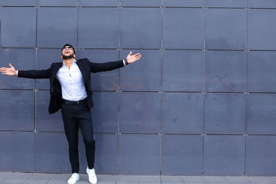 Full length of young man standing against wall