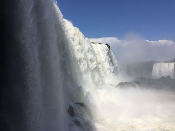 Scenic view of waterfall against sky