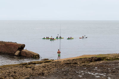 Man fishing on seashore