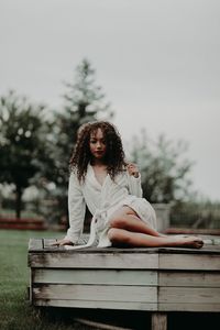 Portrait of woman sitting against trees