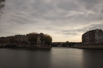 Arch bridge over river against buildings in city